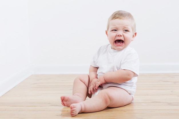 Bebe Pleure Assis Sur Le Plancher En Bois Photo Premium