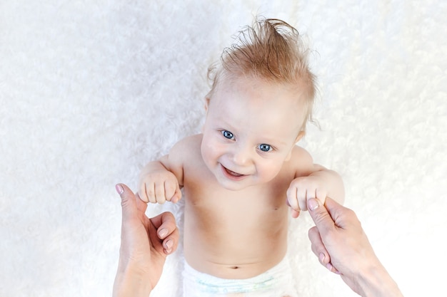 Un Bebe De Six Mois De Type Caucasien Les Yeux Bleus Couches Gros Plan Maman Le Prend Dans Ses Bras Photo Premium