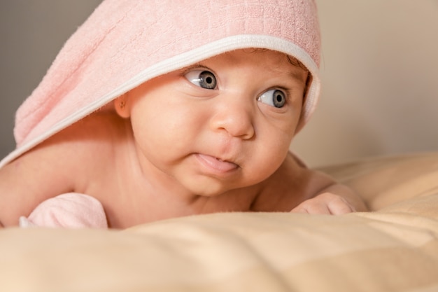 Bebe Surpris Avec De Grands Yeux Bleus Et La Bouche Ouverte Couche Sur Le Ventre Sous La Serviette Rose Apres Le Bain Photo Premium