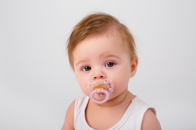 Bebe Avec Une Tetine Dans Sa Bouche Sur Un Fond Blanc Photo Premium