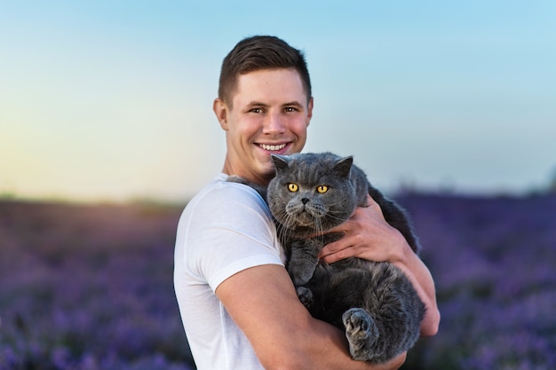 Bel Homme Avec Un Chat Britannique Dans Le Champ De Lavande Au Coucher Du Soleil Ambiance Estivale Fantastique Photo Premium