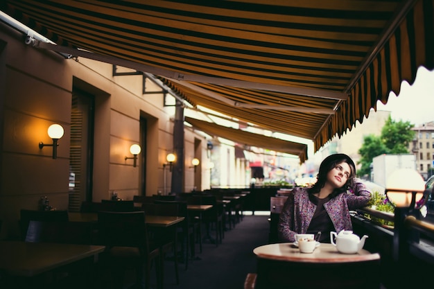 Belle femme avec une tasse de thé assis dans un café. Photo Premium