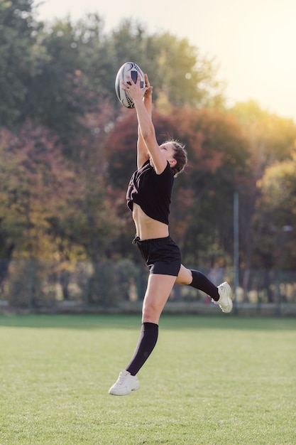 Belle Fille Attraper Un Ballon De Rugby Photo Gratuite