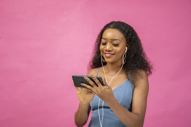 Belle Jeune Femme Africaine Regardant Une Vidéo à L aide De Son Téléphone Tout En Portant Une