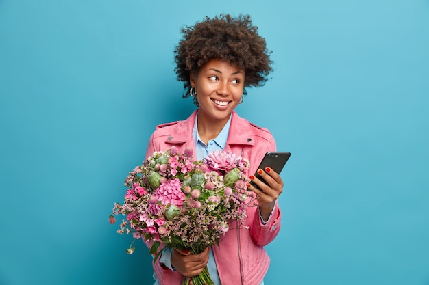 Belle Jeune Femme Reflechie Recoit Des Felicitations Sur Le Smartphone Fete Son Anniversaire Obtient Un Joli Bouquet De Fleurs Photo Gratuite