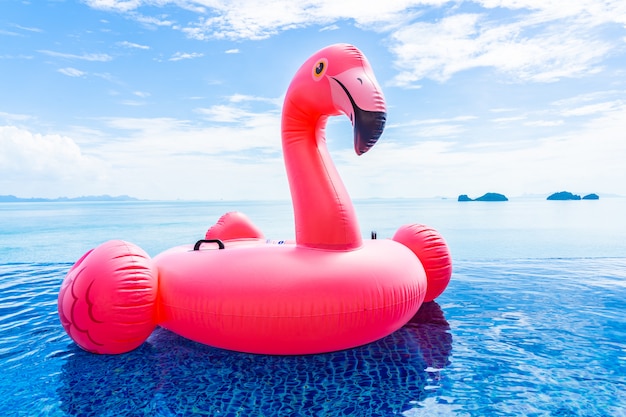 Belle piscine extérieure dans un complexe hôtelier avec flamant rose flottant autour d'un nuage blanc de mer, océan, sur ciel bleu Photo gratuit