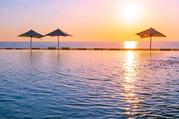 Belle piscine en plein air avec parasol et chaise longue dans le complexe hôtelier pour se détendre Photo gratuit