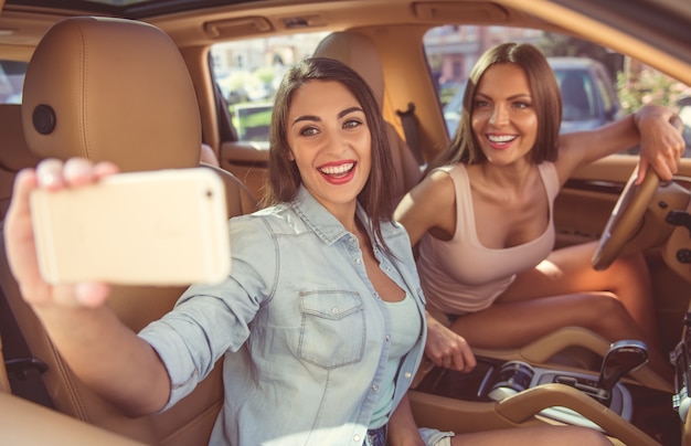 Belles filles élégantes font selfie en utilisant un smartphone Photo Premium