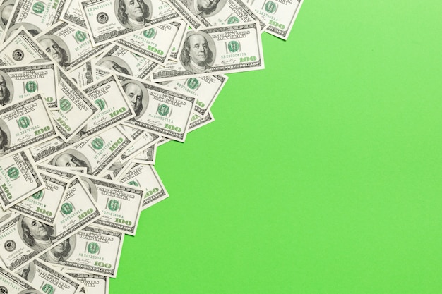 Billets de vue de dessus sur un bureau coloré avec fond sur le dessus. billets de cent dollars avec pile d’argent au milieu. vue de dessus des affaires Photo Premium