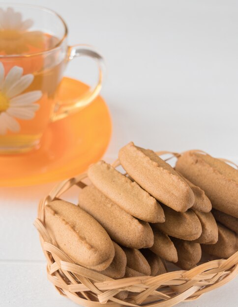 Biscuits de pain d'épice à la main sur une table en bois blanche. Photo Premium