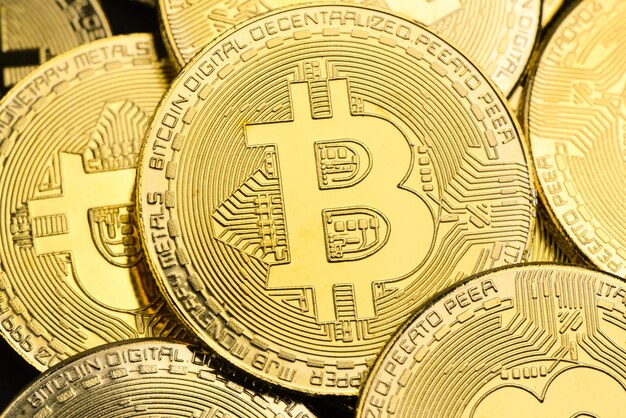 Bitcoins dorés brillants comme toile de fond, concept de crypto-monnaie et d’argent virtuel Photo Premium