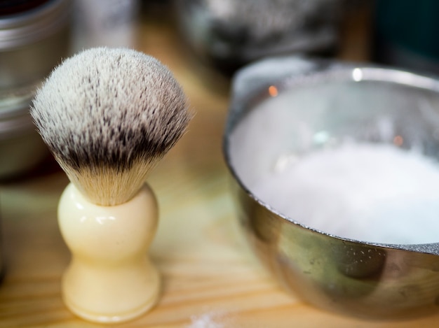 Blaireau et crème dans un salon de coiffure Photo gratuit