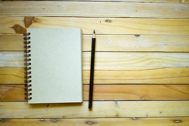  Bloc  notes  avec un crayon sur fond  de planche  bois usage 