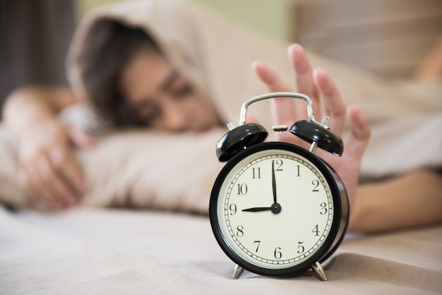 Bonne Fille Se Réveiller Le Matin En éteignant Le Réveil Dans Sa 