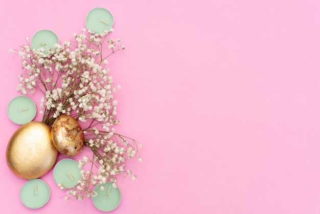 Bougies à la menthe sur fond rose, fleurs séchées et feuille d'or Photo Premium