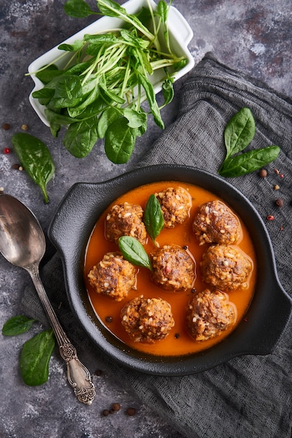 Boulettes de viande faites maison avec sauce tomate et épinards dans une assiette, vue de dessus Photo Premium