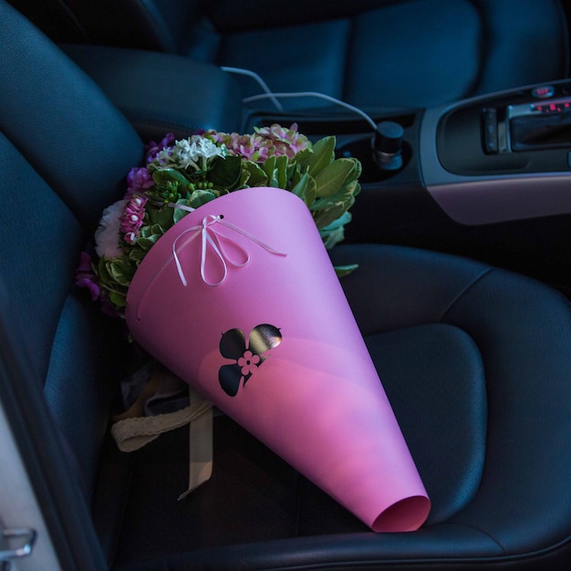 Un Bouquet De Papier Portable De Fleurs Debout Sur Un Siège Dans Une Voiture Photo gratuit