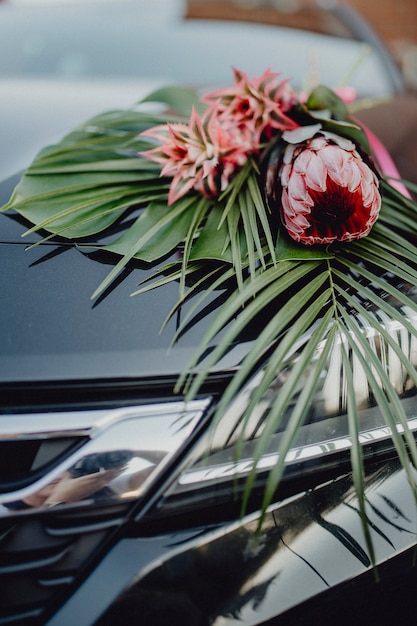 Un Bouquet De Roi Protea Et Dananas Rouges Sur Le Capot D