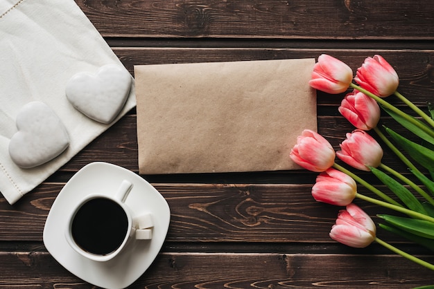 Bouquet de tulipes roses avec une tasse de café et de pain d'épice blanc en forme de coeur Photo Premium