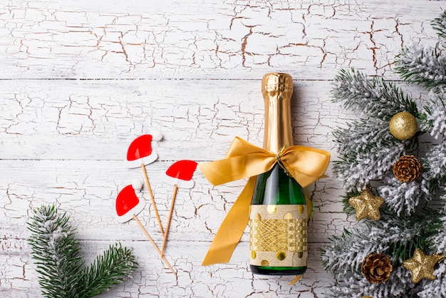 Bouteille de champagne dans un emballage d'or avec une décoration de noël Photo Premium