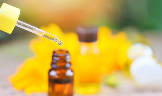 Bouteilles D'huile D'aromathérapie à Base De Plantes Arôme Compte-gouttes Sur Verre Avec Fleur Sur Fond Vert Nature - Huiles Essentielles Naturelles Pour Les Remèdes De Beauté Pour Le Visage Et Le Corps Sur Table En Bois Et Minimalis Organiques Photo Premium