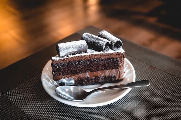 Brownie Cake Wite Une Roulette De Chocolat Posee Sur Une Assiette En Ceramique Blanche Avec Une Cuillere A The Photo Premium