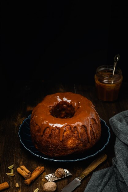 Bund Gateau Aux Epices Cannelle Anis Etoile Muscade Et Sauce Au Caramel Glacage Sur Table En Bois Fonce Photo Premium