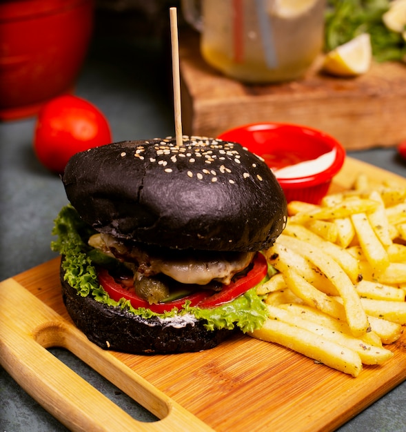 Burger au fromage de bœuf au chocolat noir avec restauration rapide de légumes, frites et ketchup. Photo gratuit
