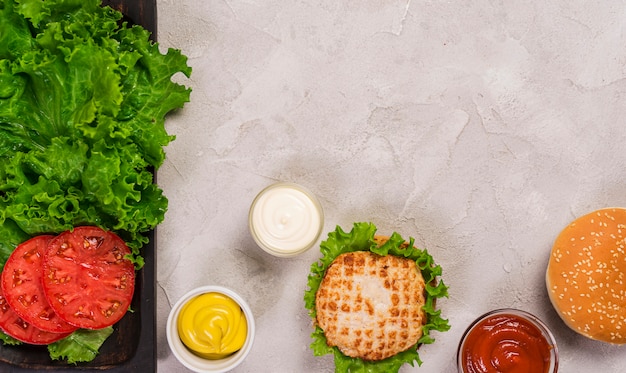 Burger classique vue de dessus avec des tranches de tomate et trempette Photo gratuit