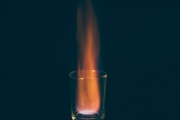 Burning shot d'alcool sur fond sombre Photo gratuit