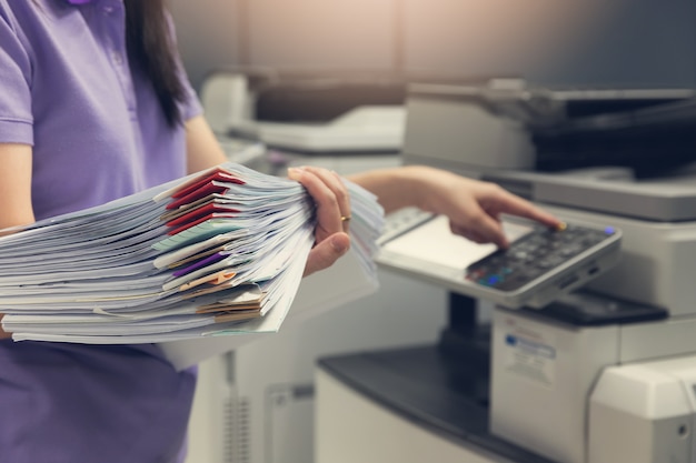 Bussinesswoman utilisant une machine à copier pour copier des documents. Photo Premium