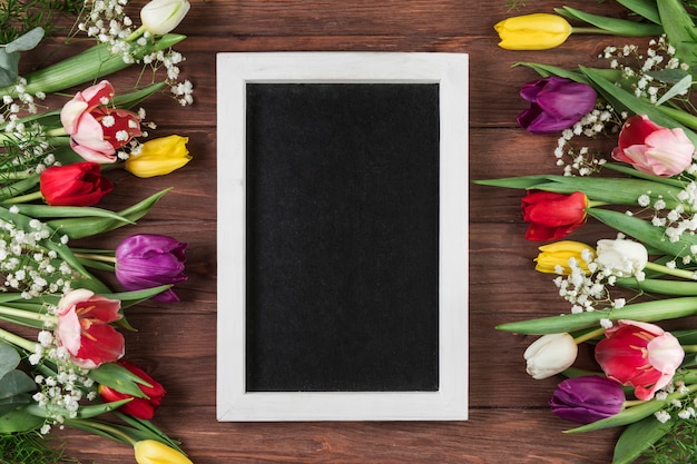 Cadre Vide Avec Bordure Blanche Entre Les Tulipes Colorees Et La Fleur D Haleine De Bebe Sur Le Bureau En Bois Photo Gratuite