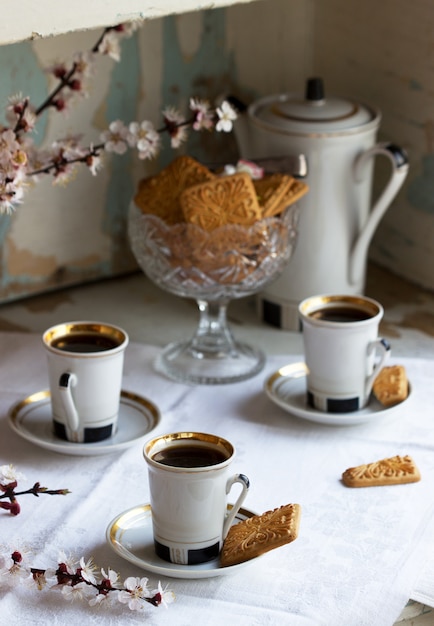 cafe-servi-biscuits-sables-bonbons-fond-branches-fleuries-vieille-armoire_134580-1540.jpg