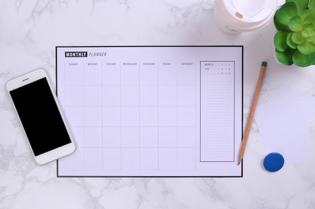 Calendrier blanc smartphone et agenda de maquette sur fond de marbre Photo Premium