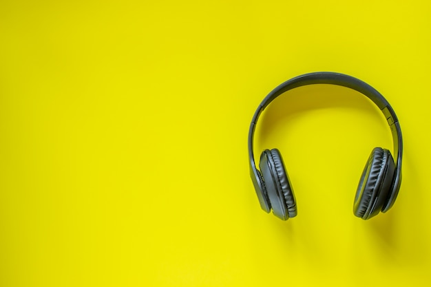Casque noir sur fond jaune. concept minimal. lay plat. Photo Premium