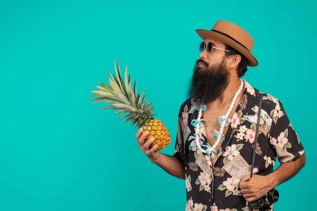Celui d'un touriste avec une longue barbe coiffé d'un chapeau et tenant l'effet sur un bleu. Photo gratuit