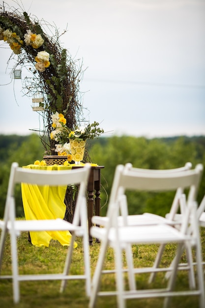 Les Chaises De Jardin Blanches Se Tiennent Devant L'autel De Mariage