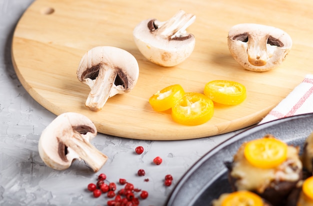 Champignons crus tranchés avec kumquats. vue de côté, gros plan, macro. Photo Premium