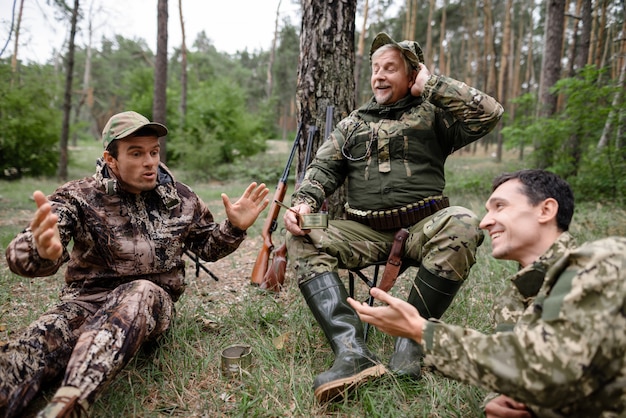 Les chasseurs saouls ont un pique-nique racontant une histoire drôle Photo Premium