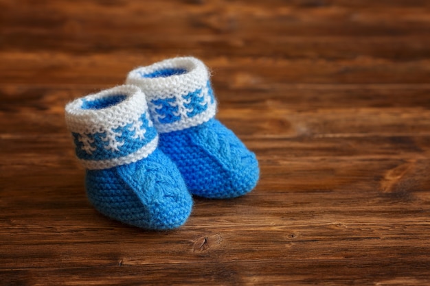 Chaussons De Bebe Au Crochet Fait Main Bleu Sur Fond De Bois Photo Premium