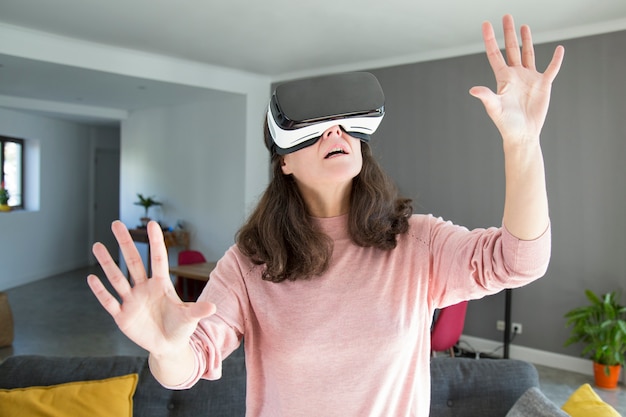 Choqué jeune femme apprenant le monde dans le casque de réalité virtuelle Photo gratuit