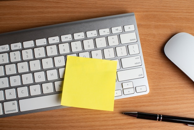 Clavier et souris avec bloc-notes jaune et stylo noir Photo Premium