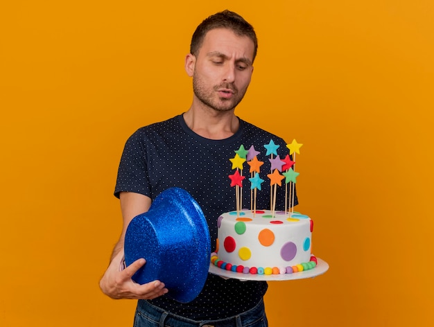 Clueless Bel Homme Detient Chapeau De Fete Bleu Et Regarde Gateau D Anniversaire Isole Sur Mur Orange Photo Gratuite