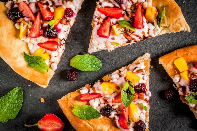 Collations D'été. Nourriture Pour La Fête. Pizza Aux Fruits à La Crème, Groseilles, Yaourt, Fraises, Mangue, Pêches, Bananes, Mûres, Chocolat, Noix, Menthe. Sur Tableau Noir. Vue De Dessus Du Fond Photo Premium