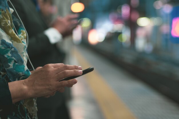 La communication. personnes utilisant un téléphone portable sur une plateforme Photo Premium