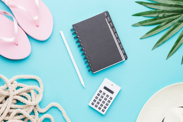 Composition d'objets de bureau et de plage sur une surface colorée Photo gratuit