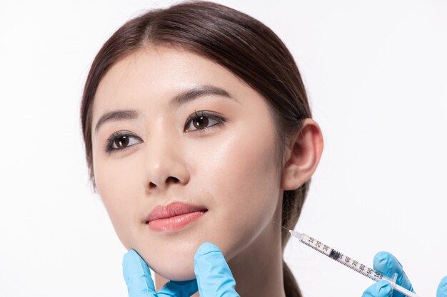 Concept de chirurgie. le médecin cosmétologue réalise la procédure d’injections faciales rajeunissantes Photo Premium