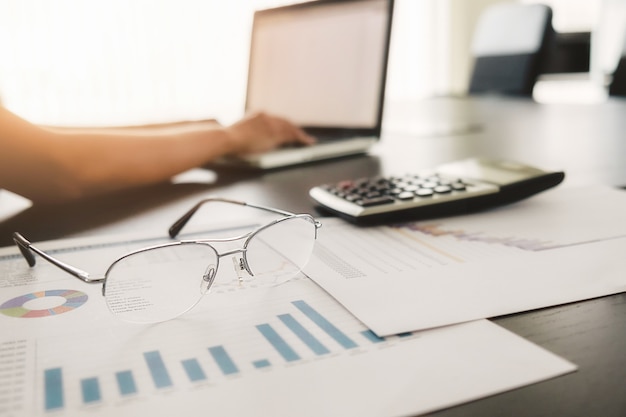 Concept d'entreprise avec espace de copie. table de bureau avec stylo et tableau d'analyse, ordinateur, ordinateur portable, tasse de café sur le bureau. tonalité de rétro filtre rétro, mise au point sélective. Photo gratuit