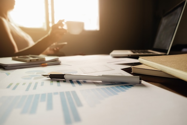 Concept d'entreprise avec espace de copie. table de bureau avec stylo et tableau d'analyse, ordinateur, ordinateur portable, tasse de café sur le bureau. tonalité de rétro filtre rétro, mise au point sélective. Photo gratuit
