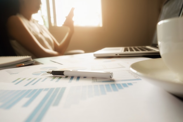 Concept d'entreprise avec espace de copie. table de bureau avec stylo et tableau d'analyse, ordinateur, ordinateur portable, tasse de café sur le bureau. tonalité de rétro filtre rétro, mise au point sélective. Photo gratuit